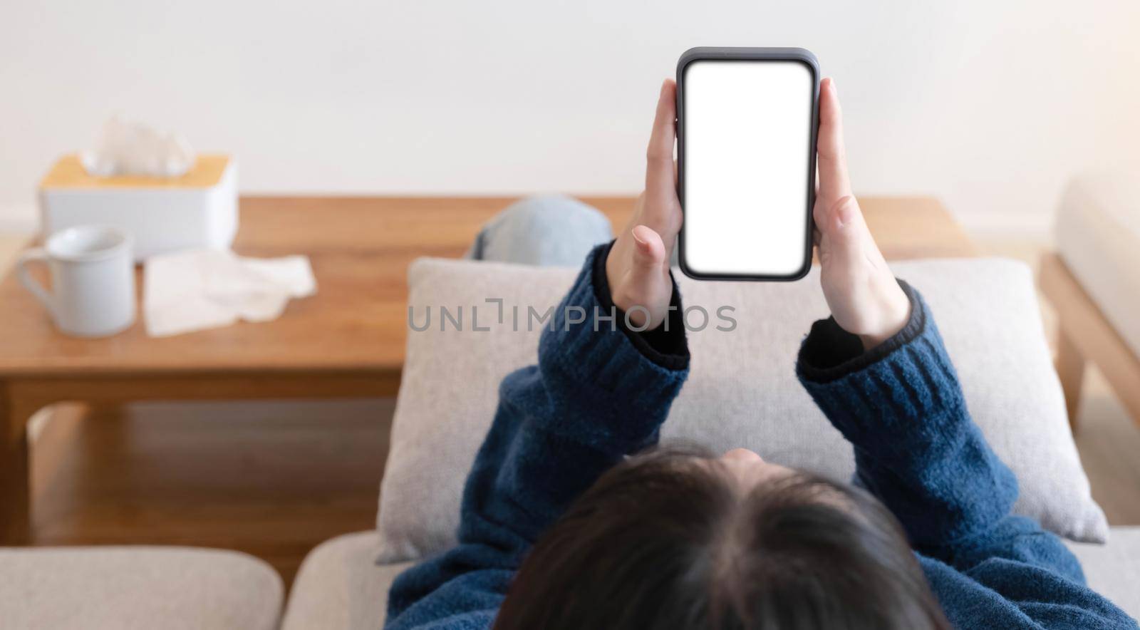 Woman configuring privacy settings on the mobile phone, lying down at home. white screen. "Privacy settings appears on the screen..
