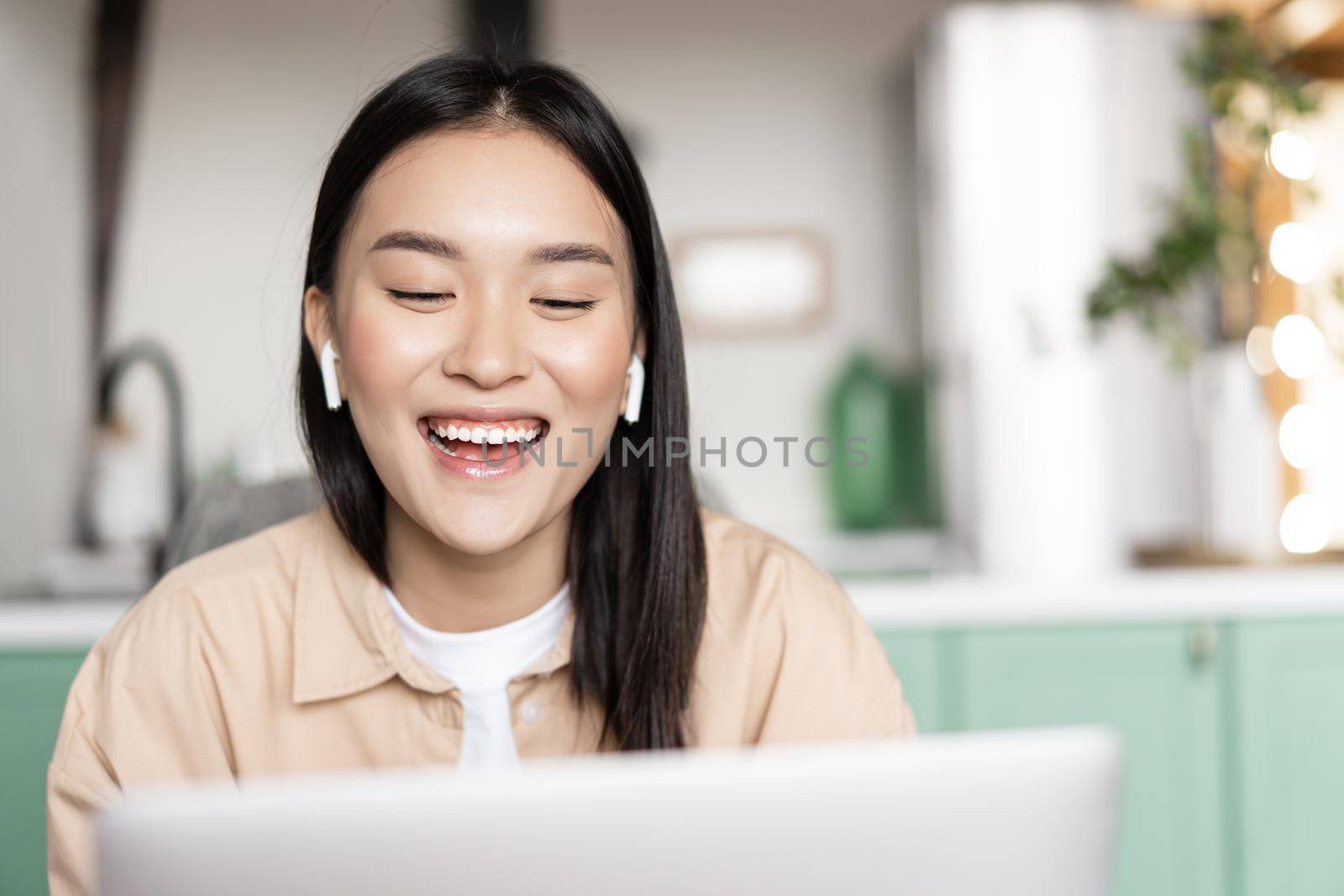 Happy smiling asian girl talking on laptop, video conference. Student studying online webinar, taking distance education course.