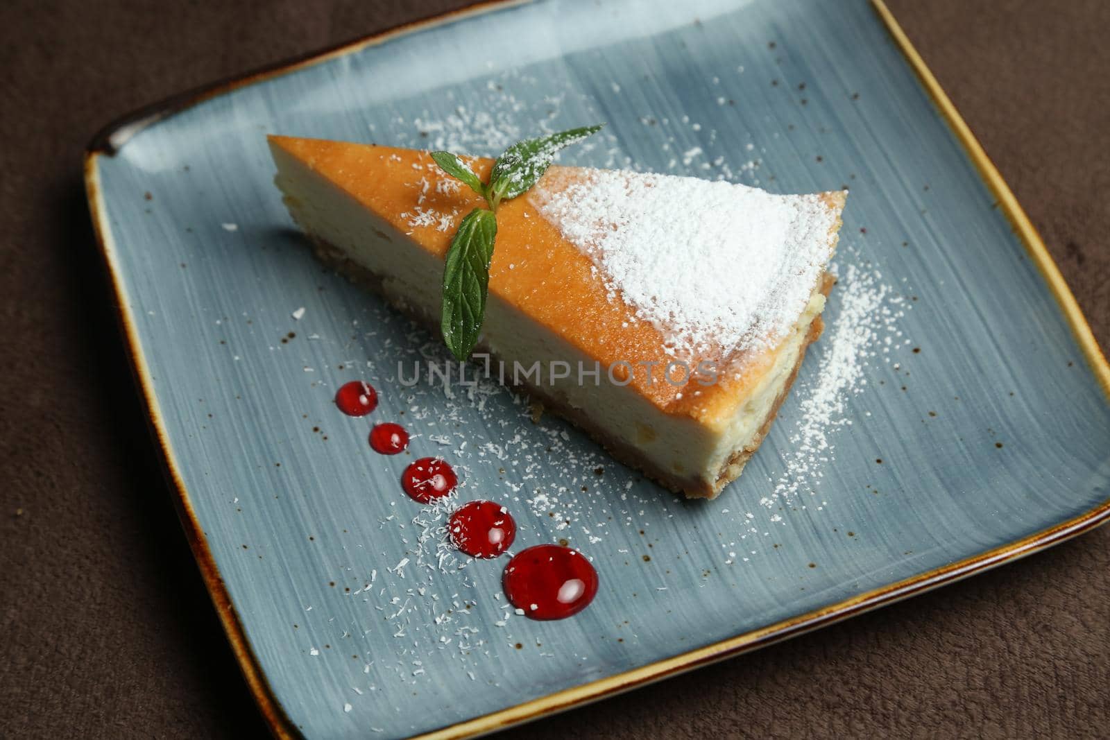 Delicious cheesecake with mint on the table nearby