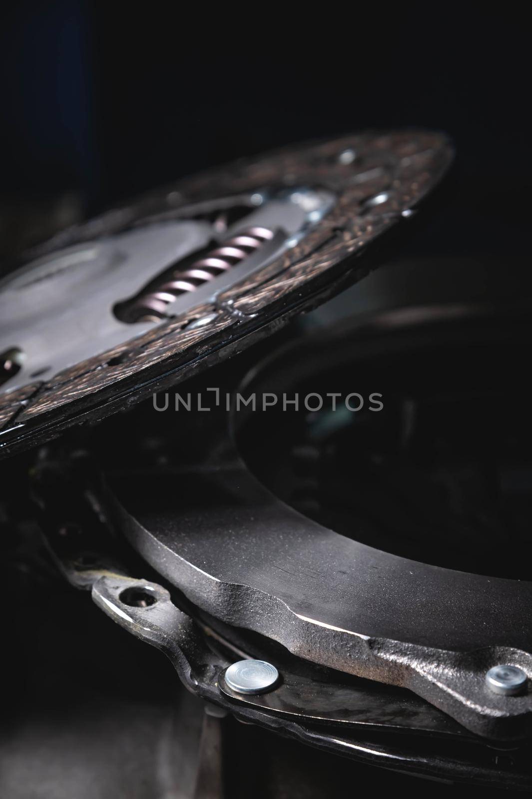 Close-up clutch disc of a car lies on metal parts contrast shot.