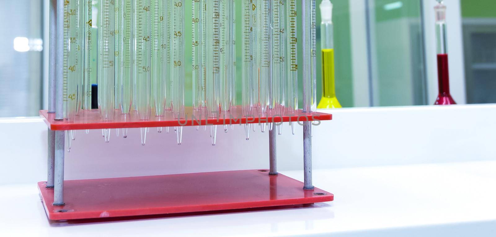 Laboratory test tubes on the stand. Stand on the table. by Hil