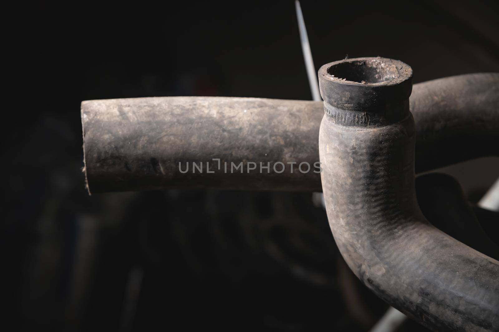 Rubber pipes and hoses leading from the car radiator to the engine, view of the engine from below. old worn rubber car cooling system hoses by yanik88