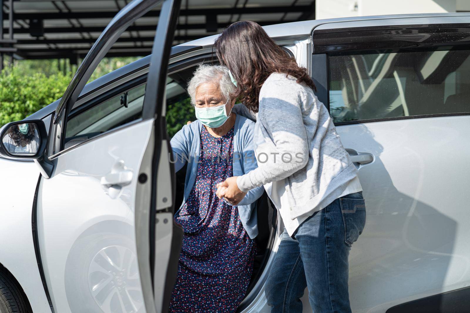 Help and support asian senior or elderly old lady woman patient walk with walker prepare get to her car, healthy strong medical concept. by pamai