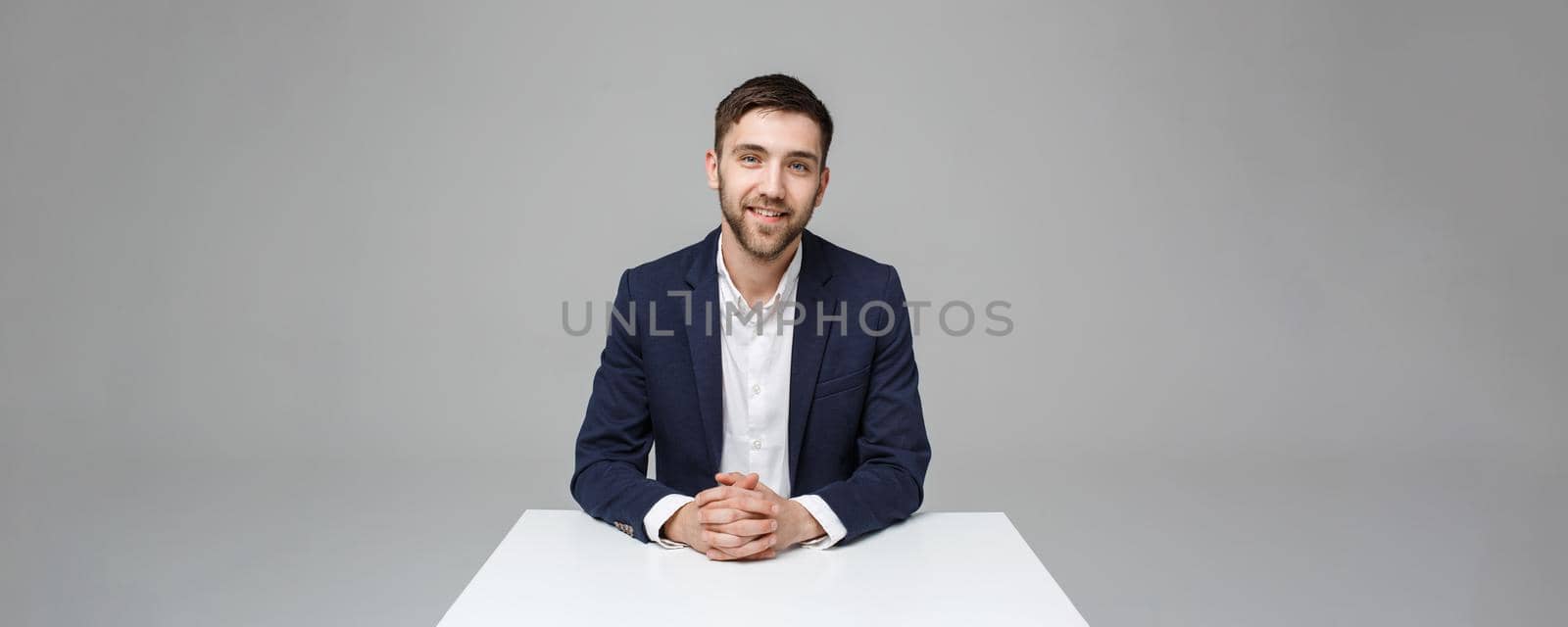 Business Concept - Portrait handsome happy handsome business man in suit smiling and siting in work office. White Background.