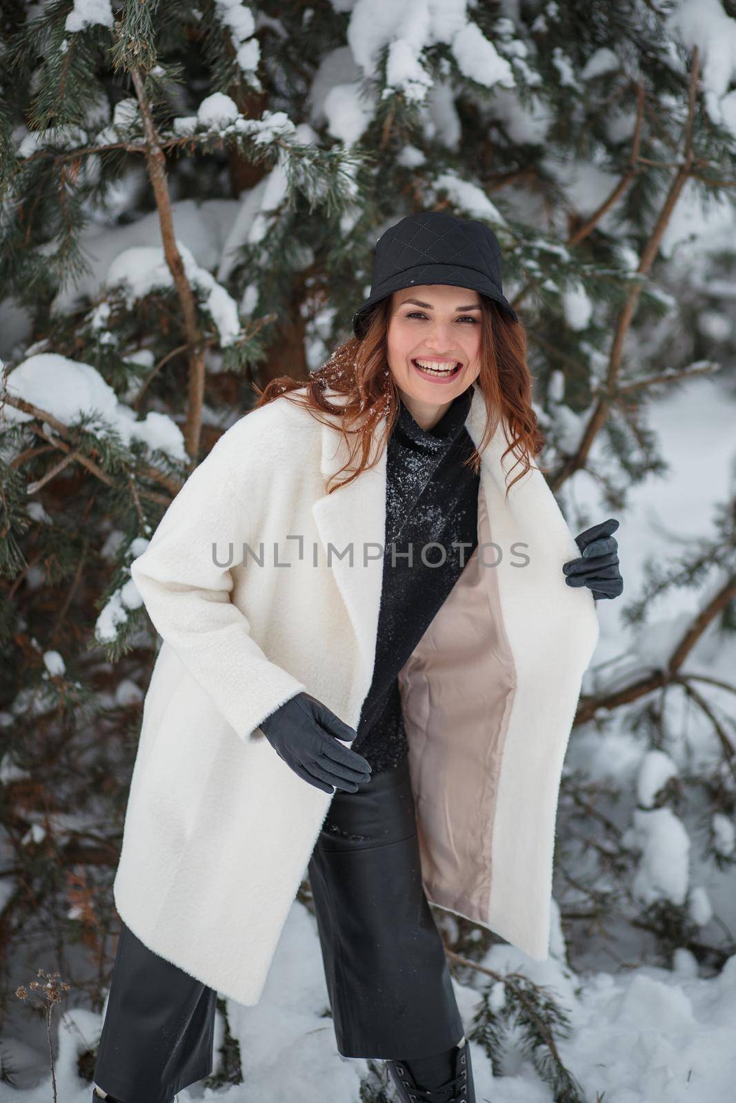 A model in the Christmas winter forest, standing under the Christmas tree.