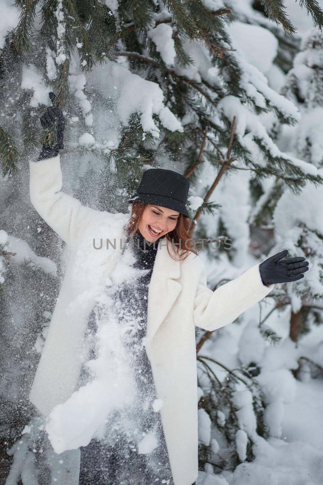 A model in the Christmas winter forest, standing under the Christmas tree.