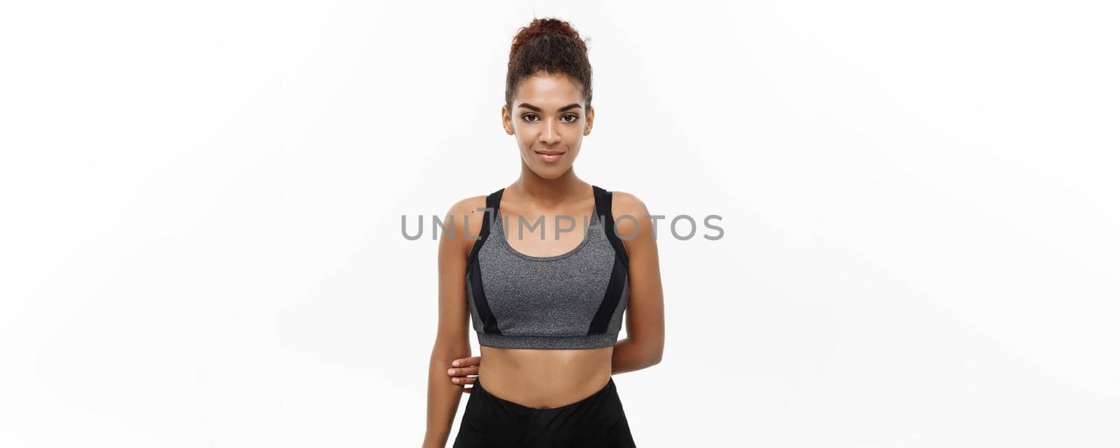 Healthy and Fitness concept - Beautiful American African lady in fitness clothes ready for workout. Isolated on white background. by Benzoix