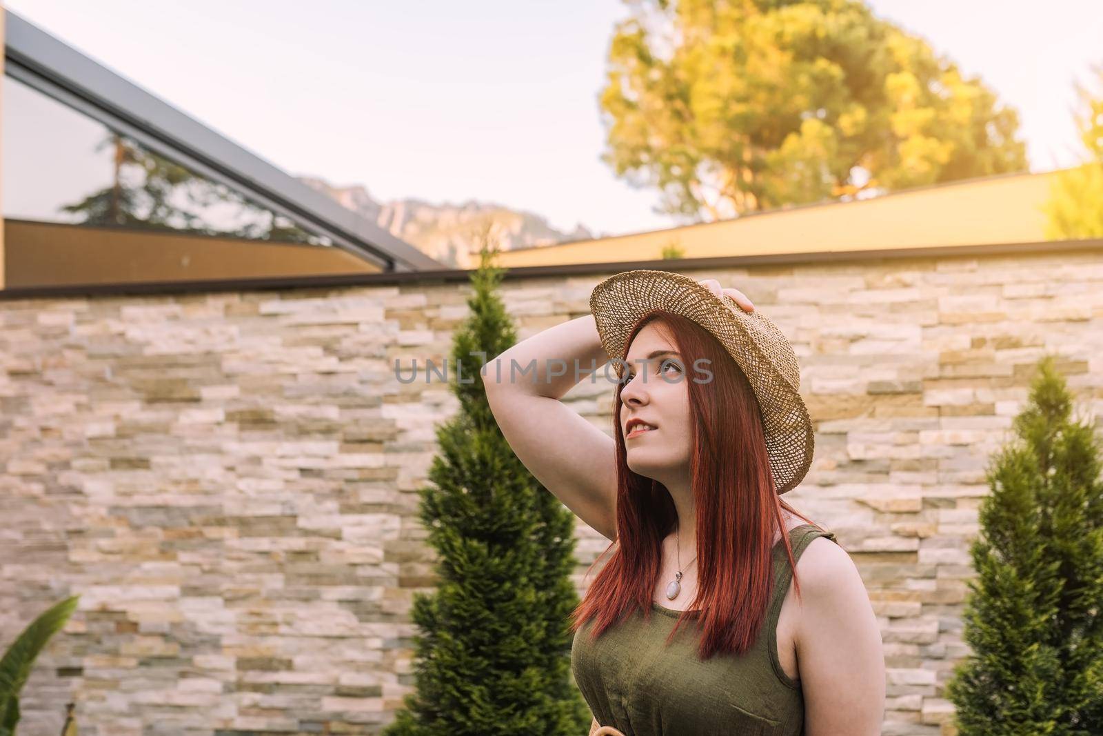 young woman relaxing, looking at the blue sky, sunbathing in the sun on a summer day. woman enjoying her holiday in the hotel garden. by CatPhotography