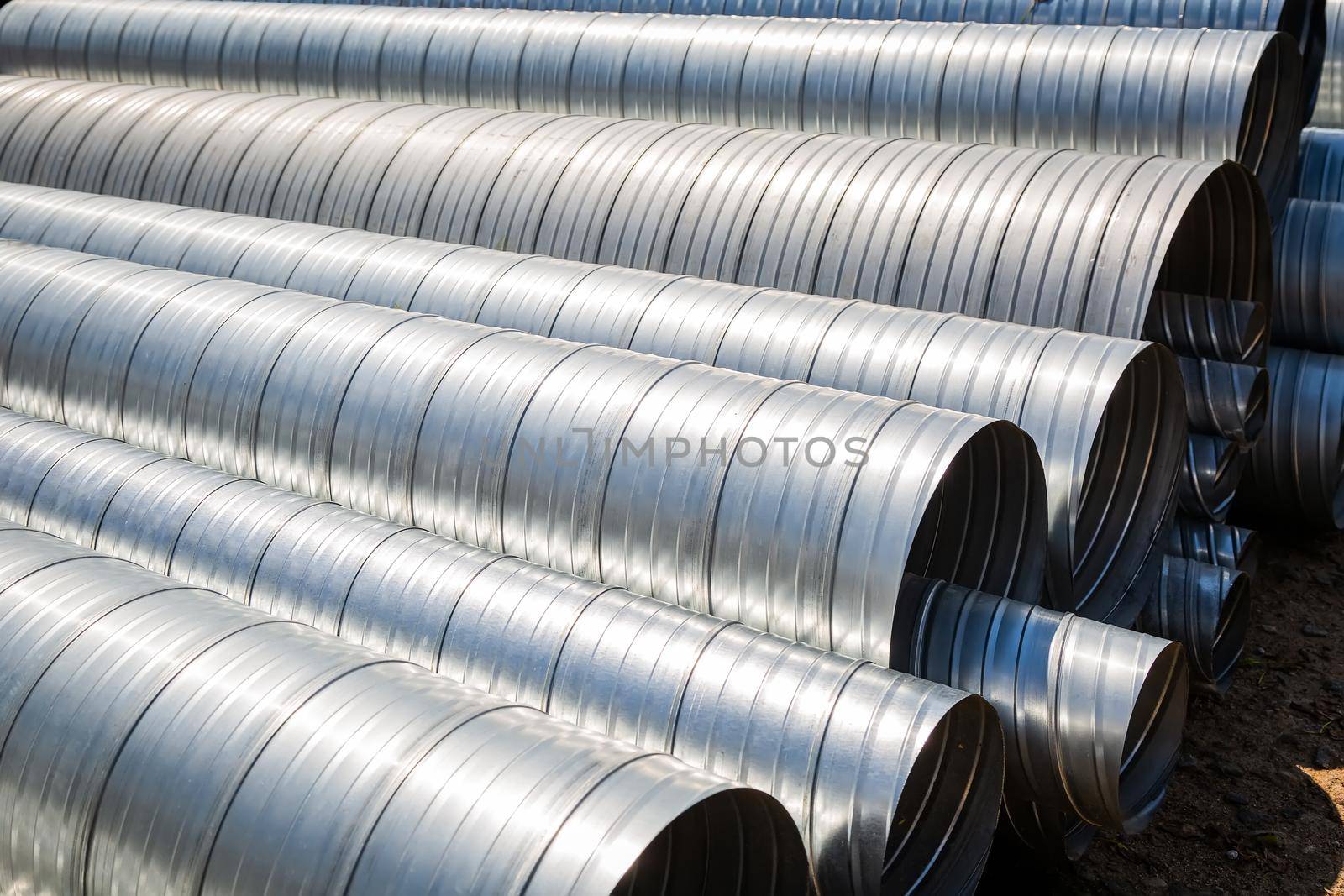 Ventilation pipe warehouse. Steel pipes, parts for the construction of air ducts for an industrial air conditioning system in a warehouse. Industrial airway ventilation equipment and piping systems.