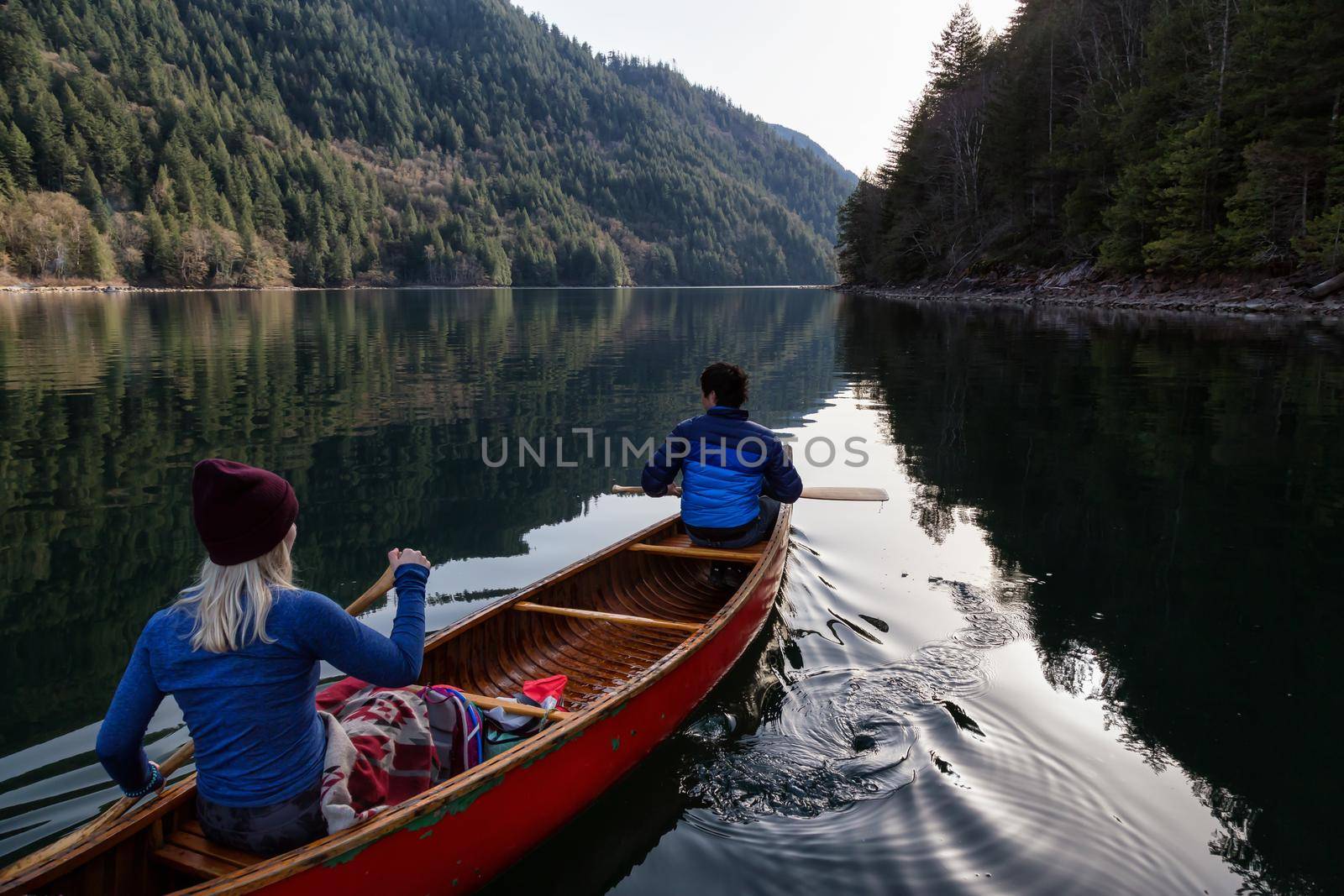 Couple friends canoeing on a wooden canoe during a sunny day by edb3_16