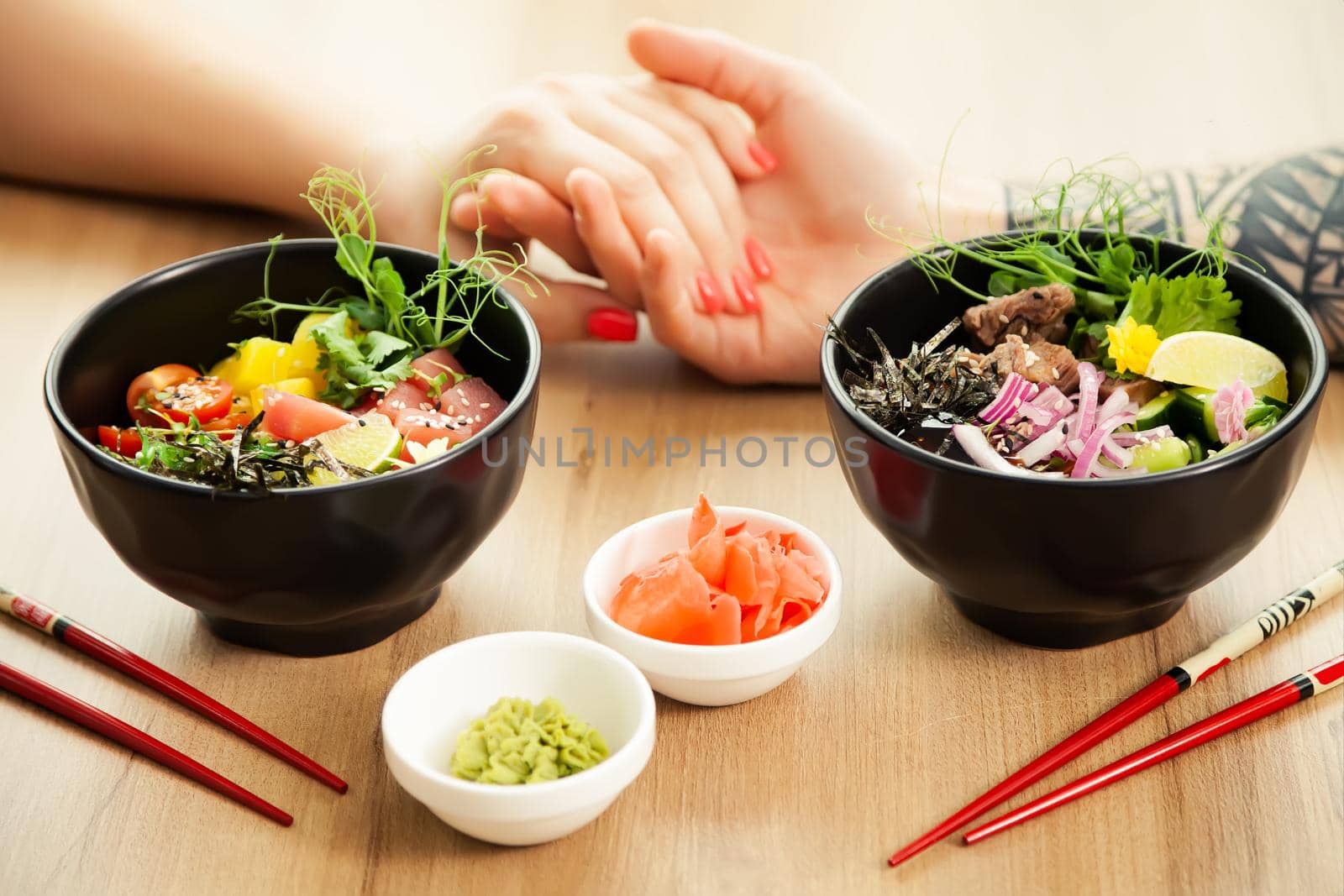 Loving couple man and woman eating salad poke chopsticks. Place the tuna salad in a bowl. People in the restaurant eat salad with chopsticks. Asian seafood salad concept