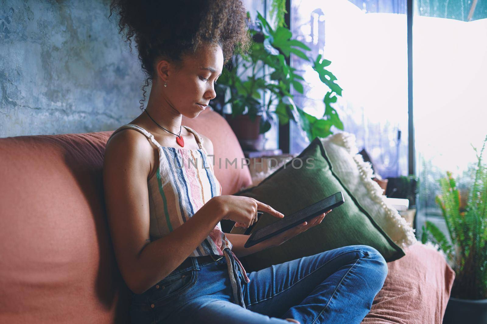 Shot of a beautiful African woman on her note pad in her living room