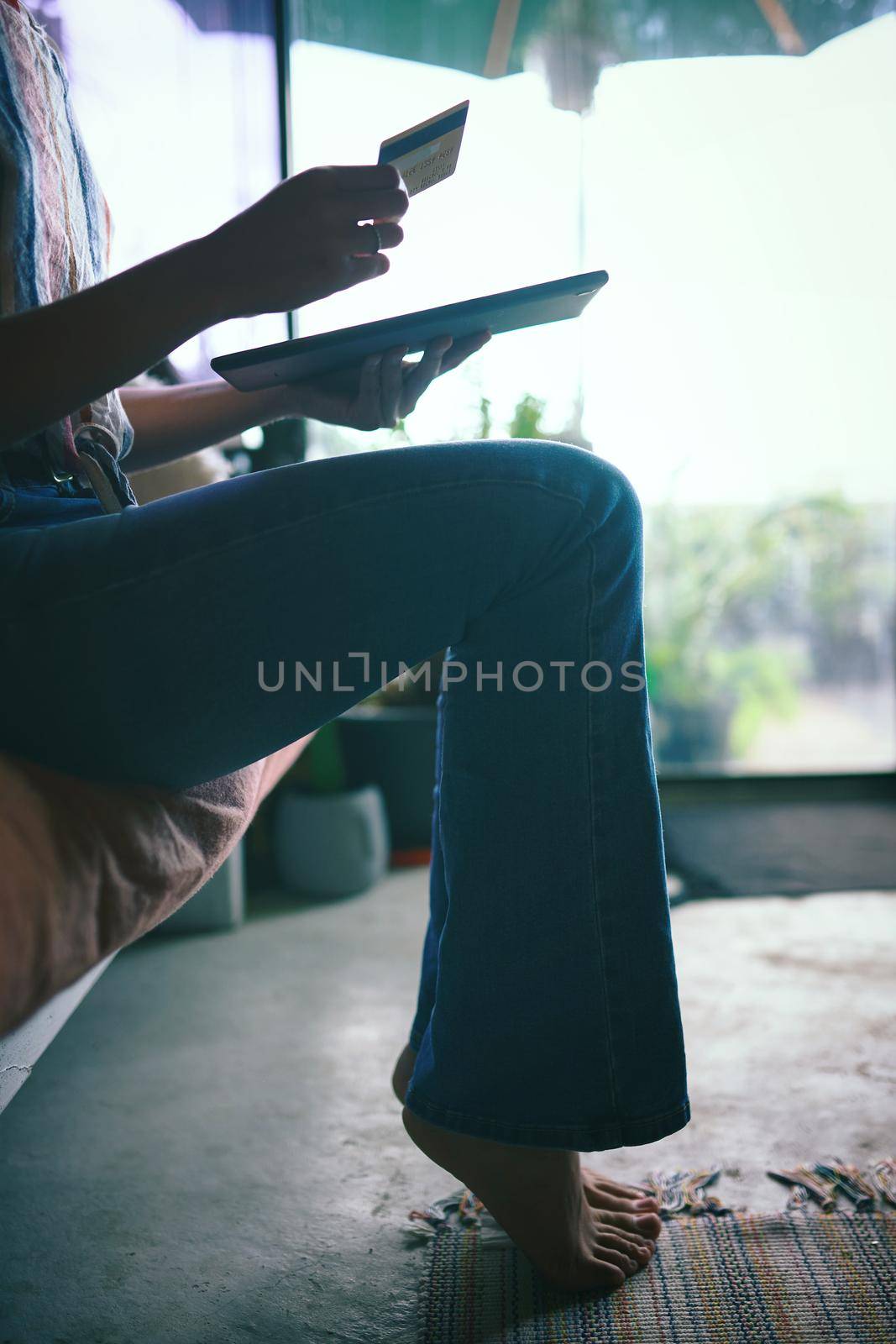 Silhouette Shot of hands holding a credit card and a tablet