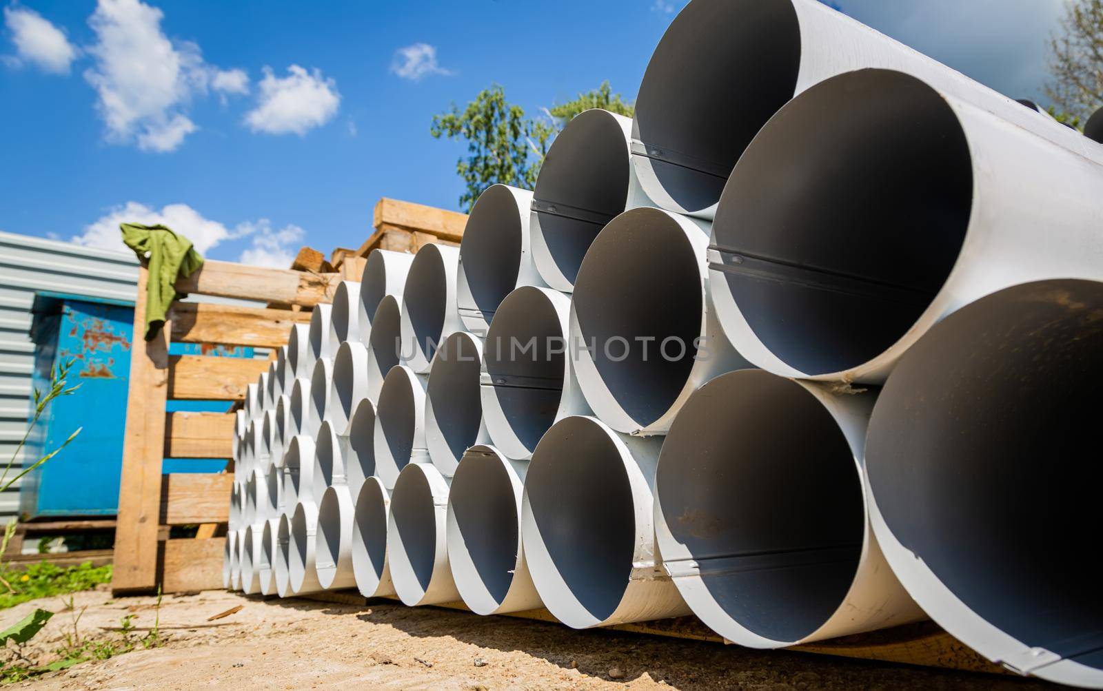 Downpipe warehouse. Steel pipes, parts for the construction of a roof drainage system in a warehouse. Stack of stainless steel pipes