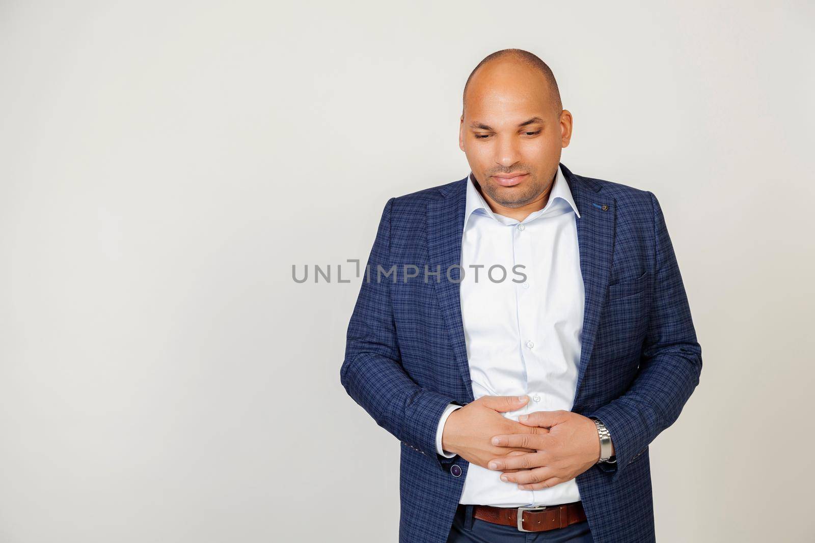 Young African American man with hand on his stomach due to indigestion, feeling sick. Pain concept