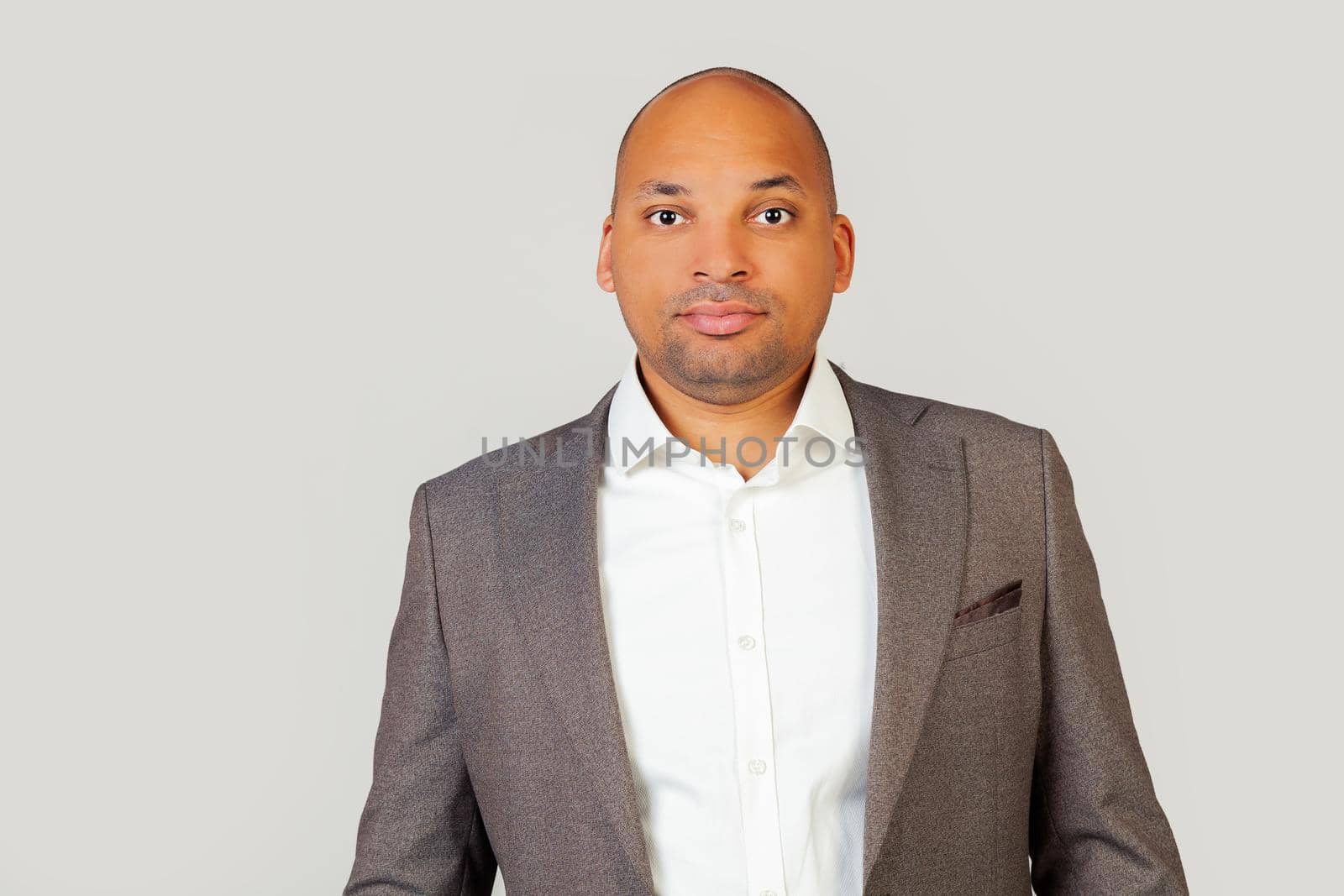 A smart confident black African-American young man, in a shirt and a jacket, a smart look, confident in his success, with a serious expression on his face. A simple and natural look at the camera
