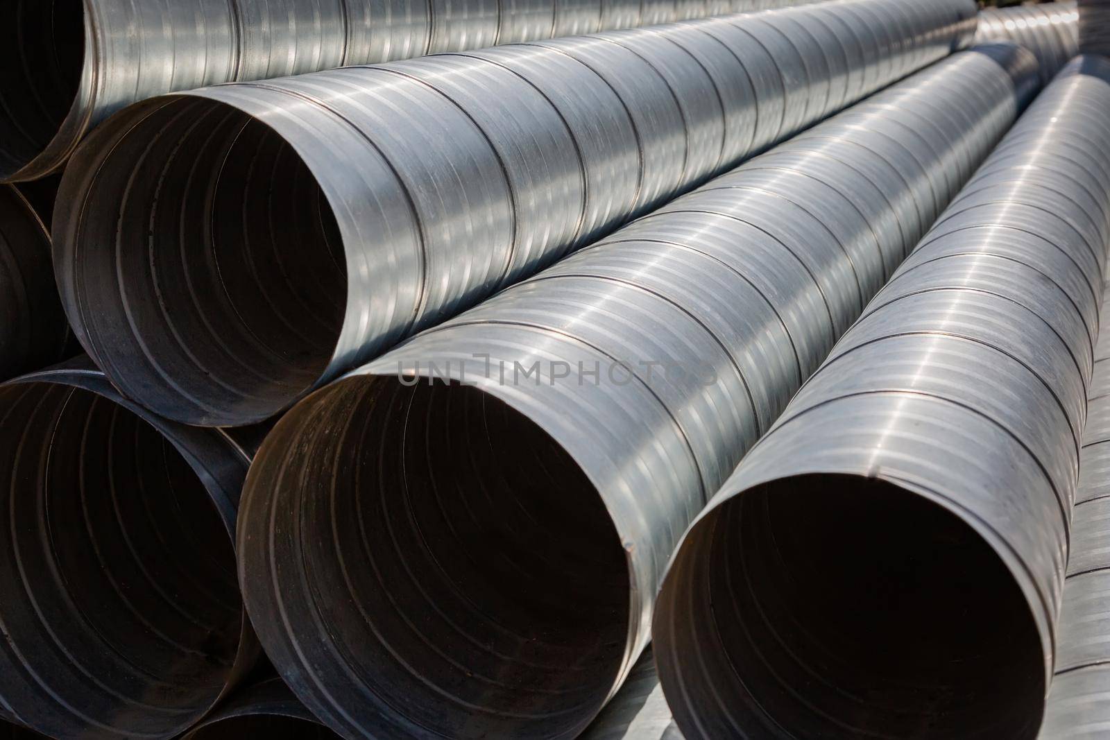 Ventilation pipe warehouse. Steel pipes, parts for the construction of air ducts for an industrial air conditioning system in a warehouse. Industrial airway ventilation equipment and piping systems.