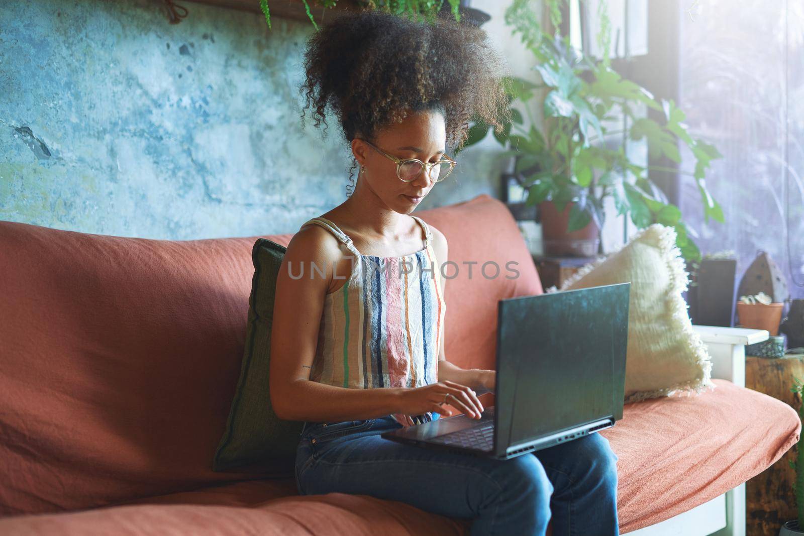 Shot of a beautiful young woman working from her sofa