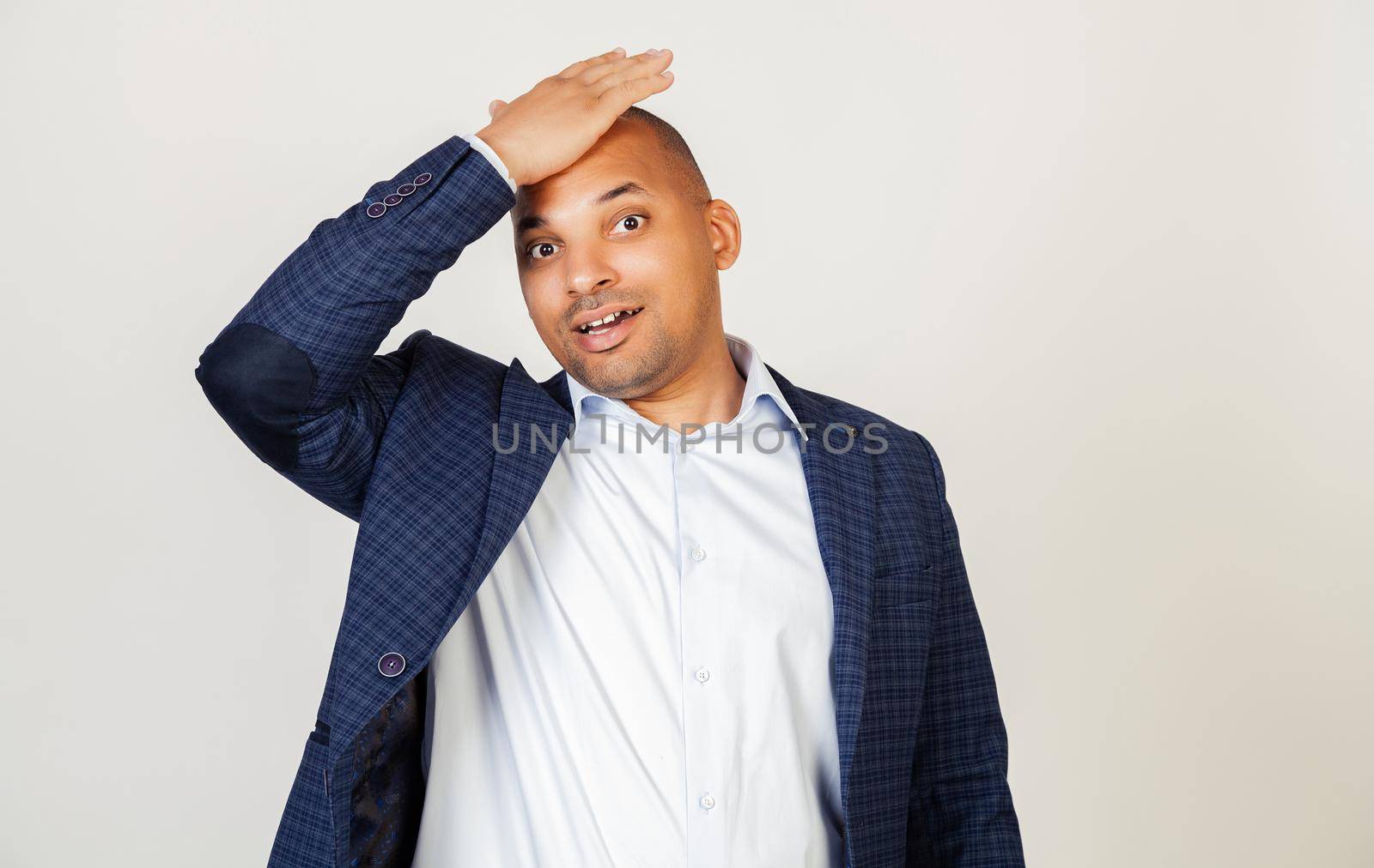 Young African American man smiling positively, resting his hand on his head for a mistake, remember a mistake. Forgot, bad memory concept. Black man.