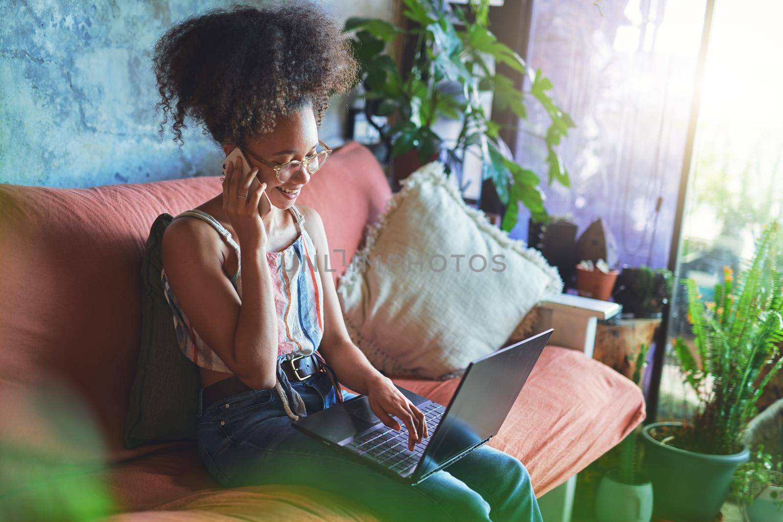 Shot of a beautiful African woman working from her living room