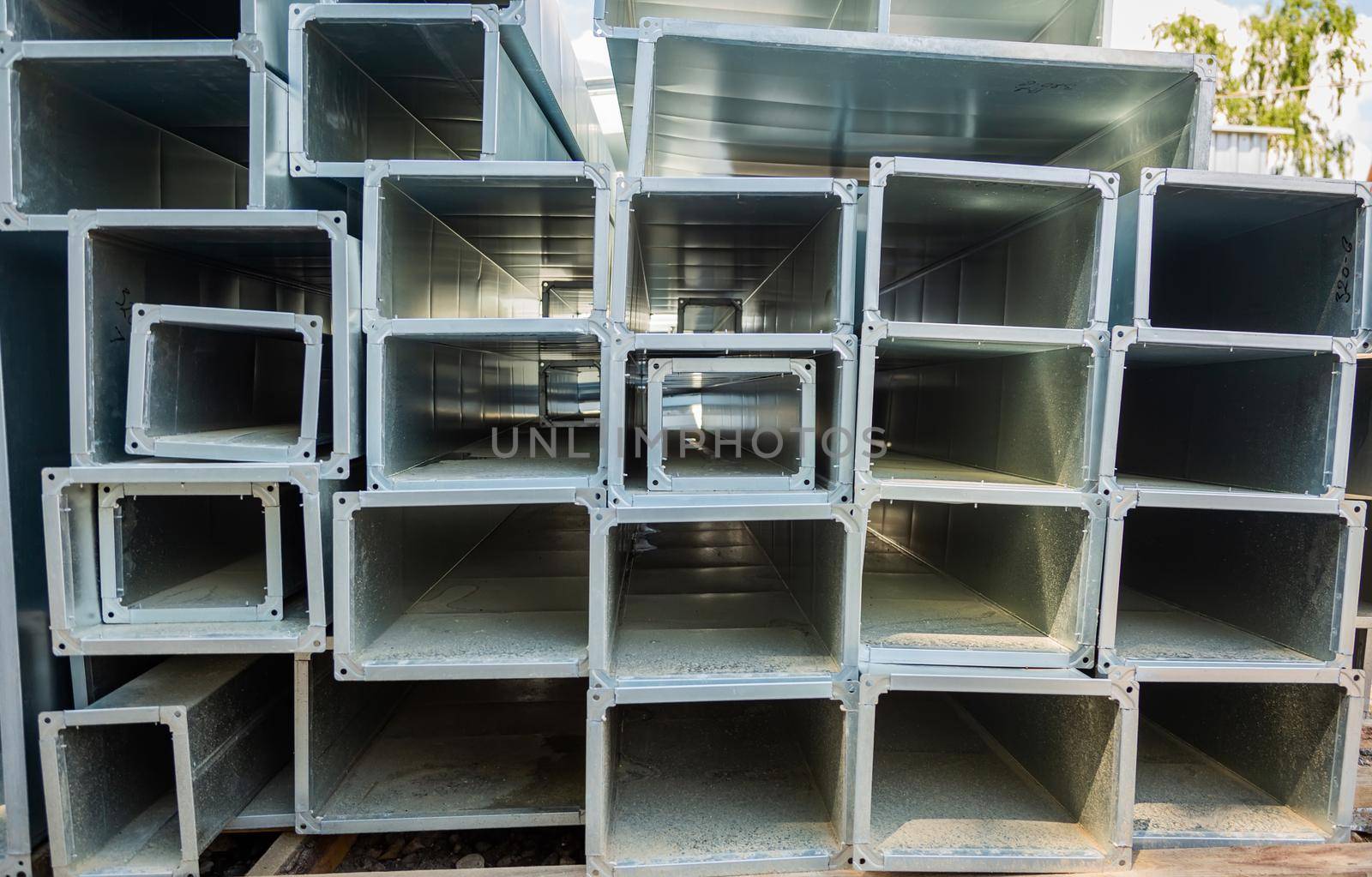 Ventilation pipe warehouse. Steel pipes, parts for the construction of air ducts for an industrial air conditioning system in a warehouse. Industrial airway ventilation equipment and piping systems.