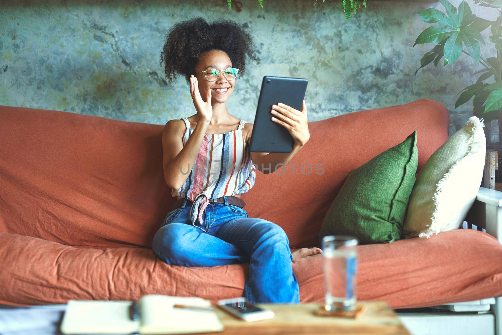 Shot of a beautiful young woman using a digital tablet for a video call in her living room