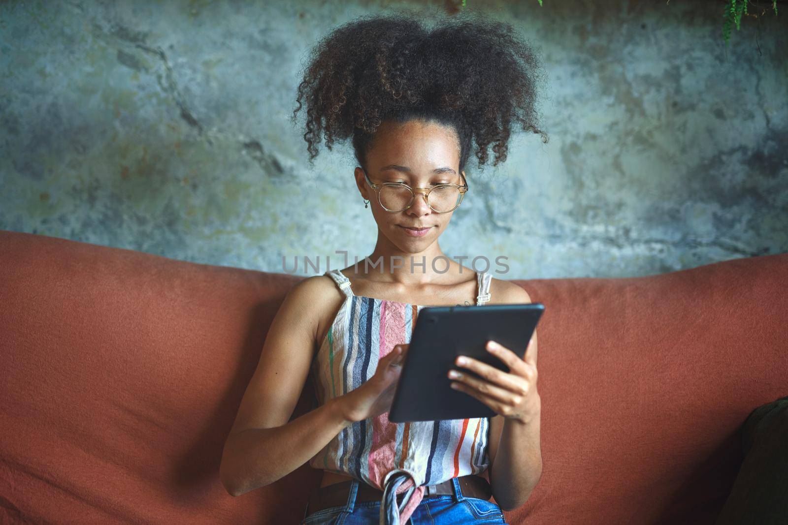 Shot of a beautiful young woman using a tablet in her living room