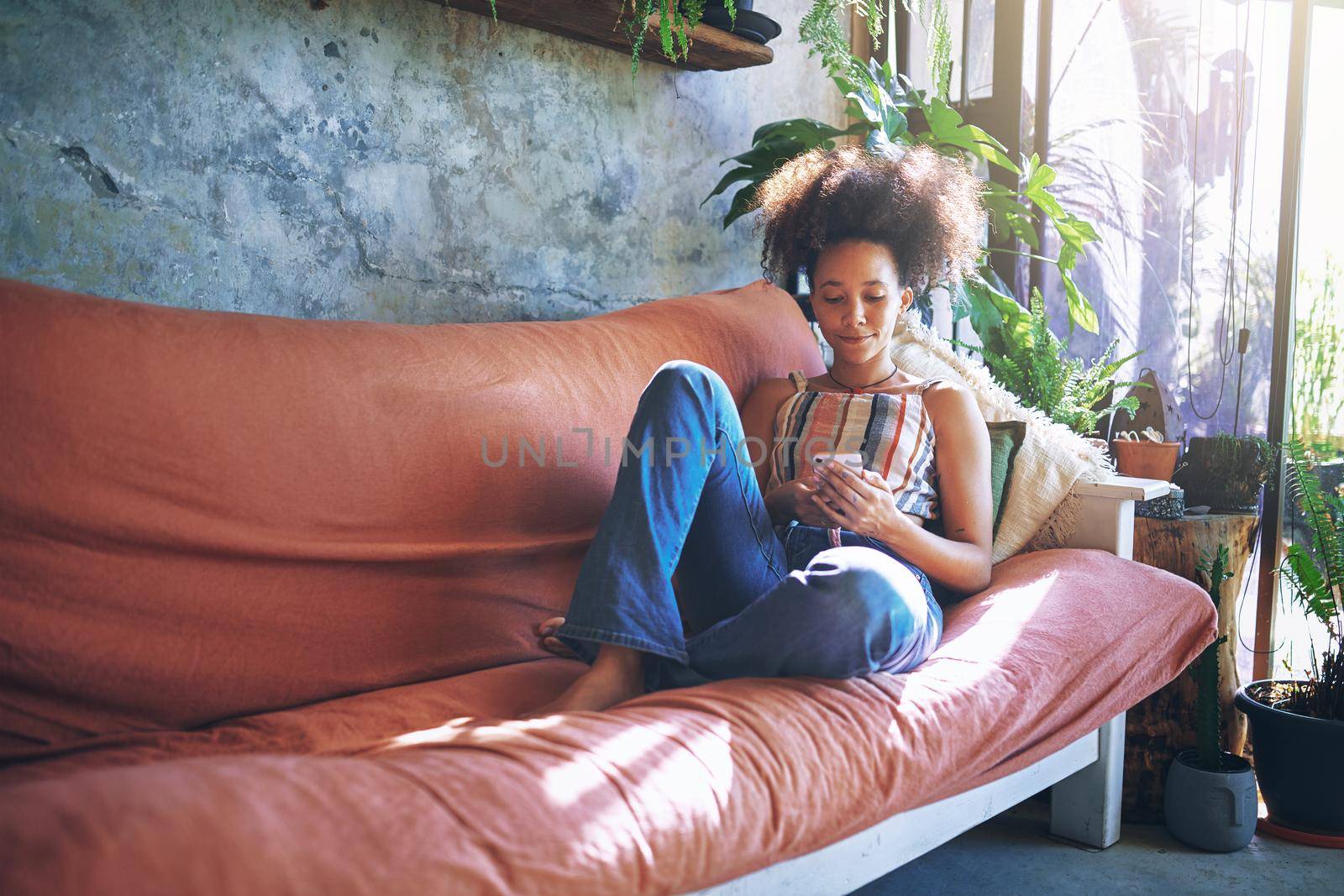 Shot of a beautiful African young woman relaxing at home - Stock Photo