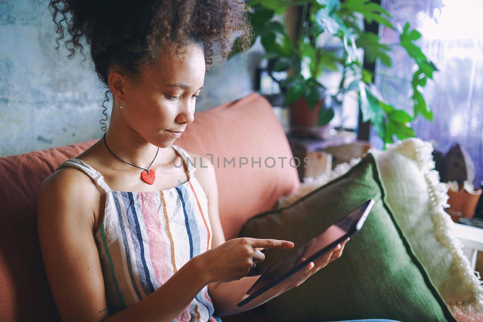 Shot of a beautiful African woman on her note pad in her living room