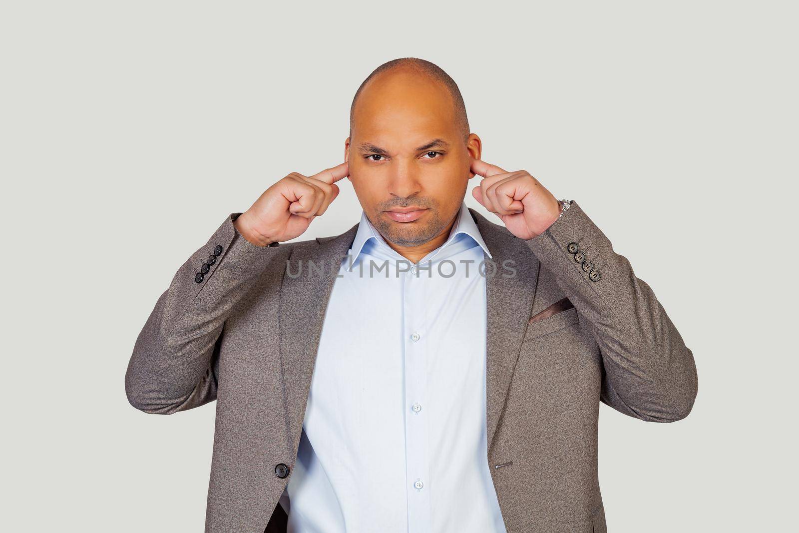 Attractive serious african american young man guy with an angry expression trying to concentrate, covering his ears with his fingers with a bored expression for the noise of loud music. Deaf concept.
