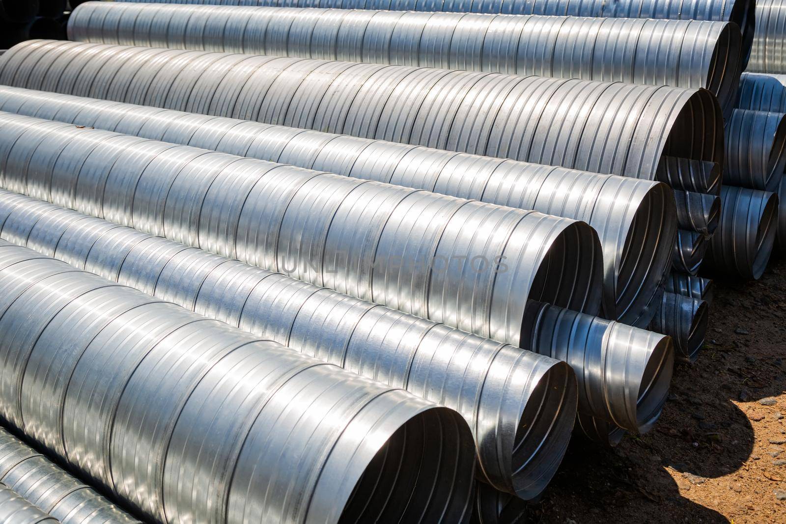 Ventilation pipe warehouse. Steel pipes, parts for the construction of air ducts for an industrial air conditioning system in a warehouse. Industrial airway ventilation equipment and piping systems.
