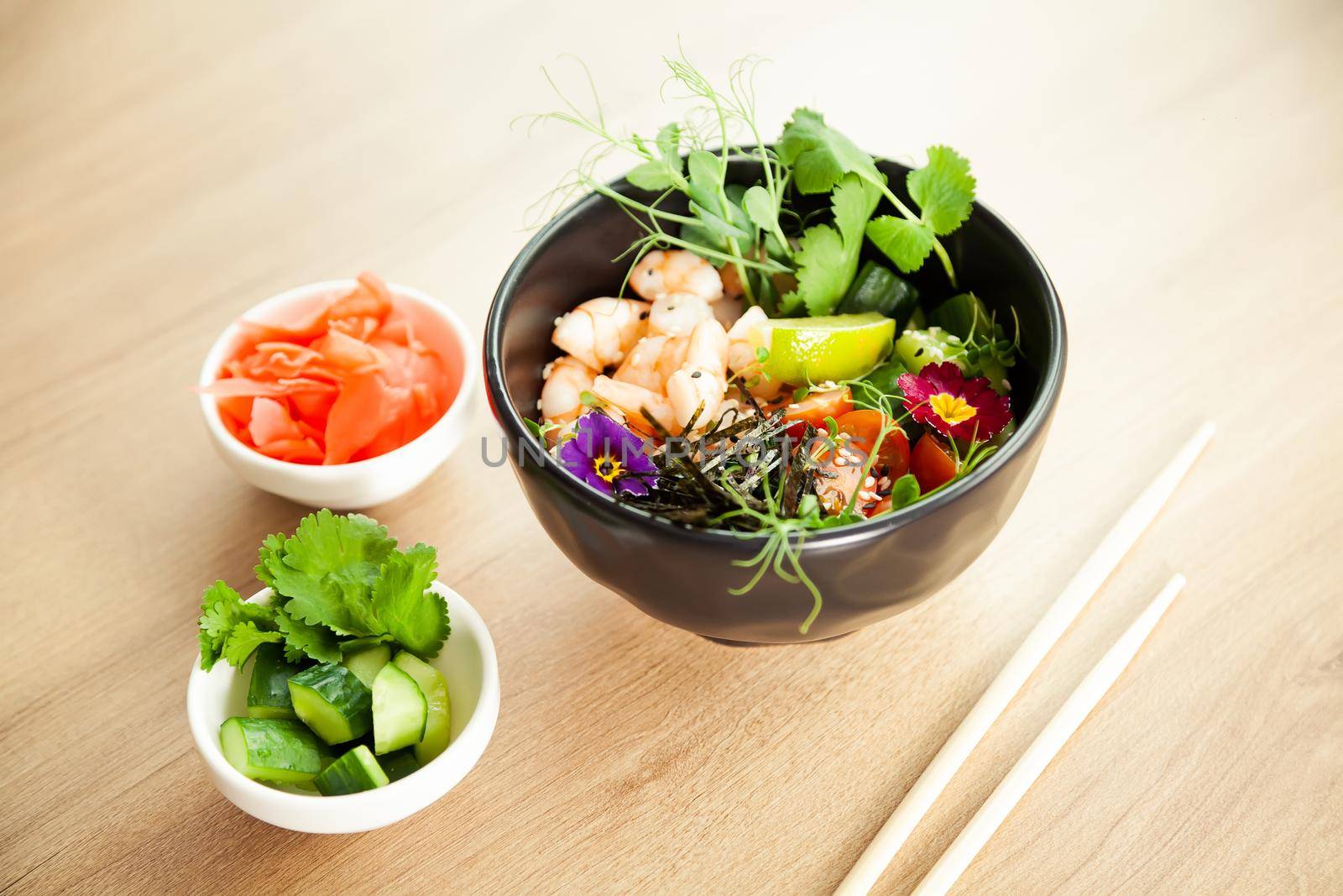 Poke salad with shrimp in a bowl. Ingredients Shrimp, blanched spinach, cherry tomatoes, rice, cucumber, soy-ginger sauce, Spicy sauce, nori, sesame, lime, cilantro. Asian seafood salad concept
