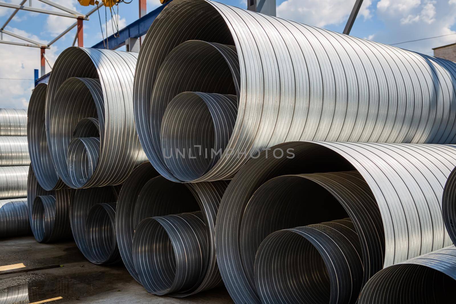 Ventilation pipe warehouse. Steel pipes, parts for the construction of air ducts for an industrial air conditioning system in a warehouse. Industrial airway ventilation equipment and piping systems.
