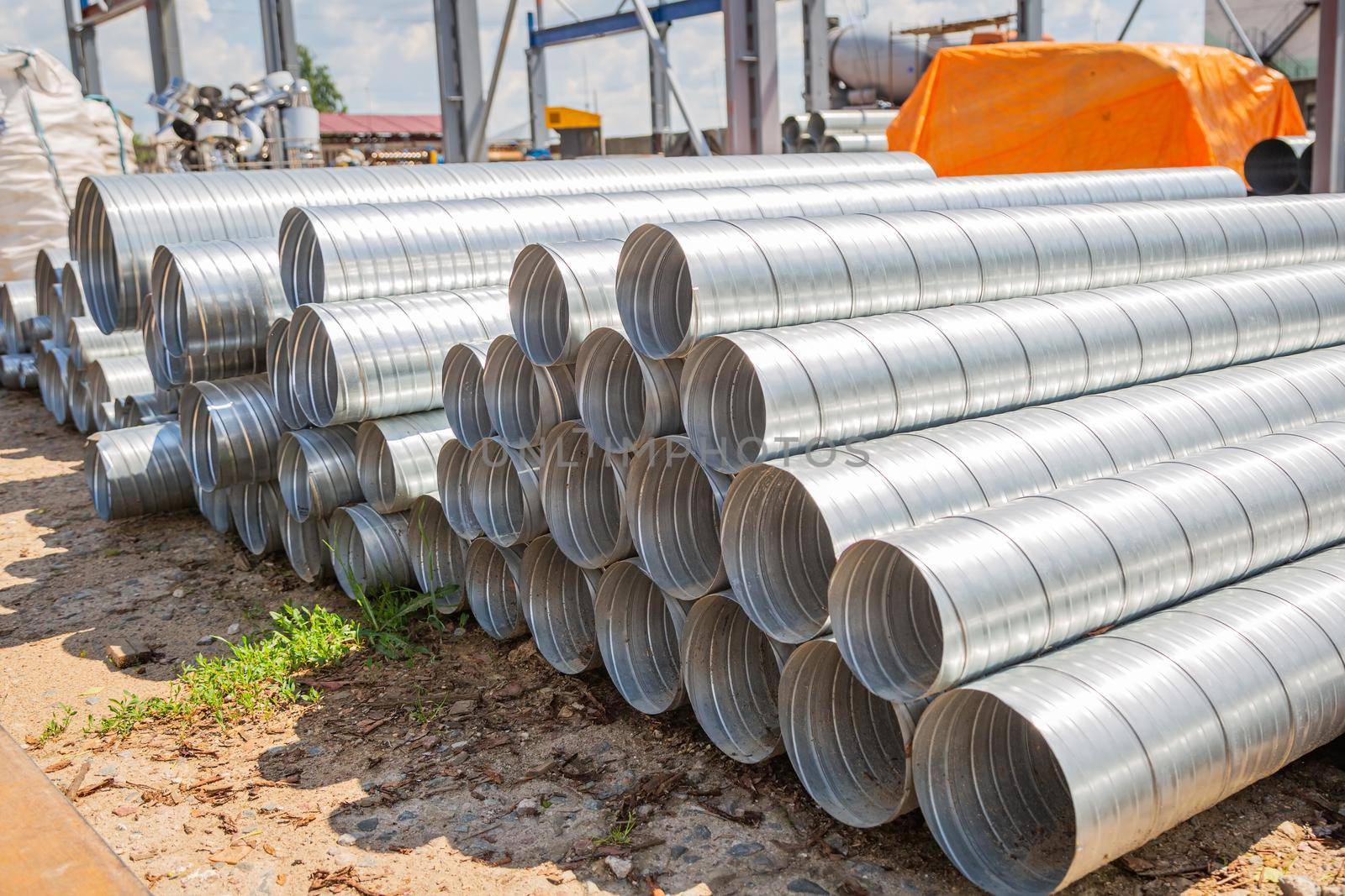 Ventilation pipe warehouse. Steel pipes, parts for the construction of air ducts for an industrial air conditioning system in a warehouse. Industrial airway ventilation equipment and piping systems.