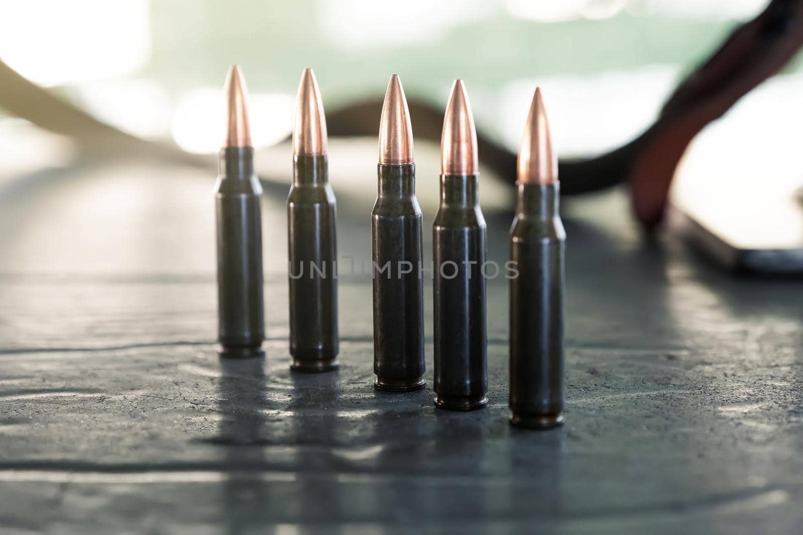 Carbine or rifle cartridges standing in a row on the table. A large number of cases. Background of brass ammunition cartridges to illustrate armed conflict, war or shooting
