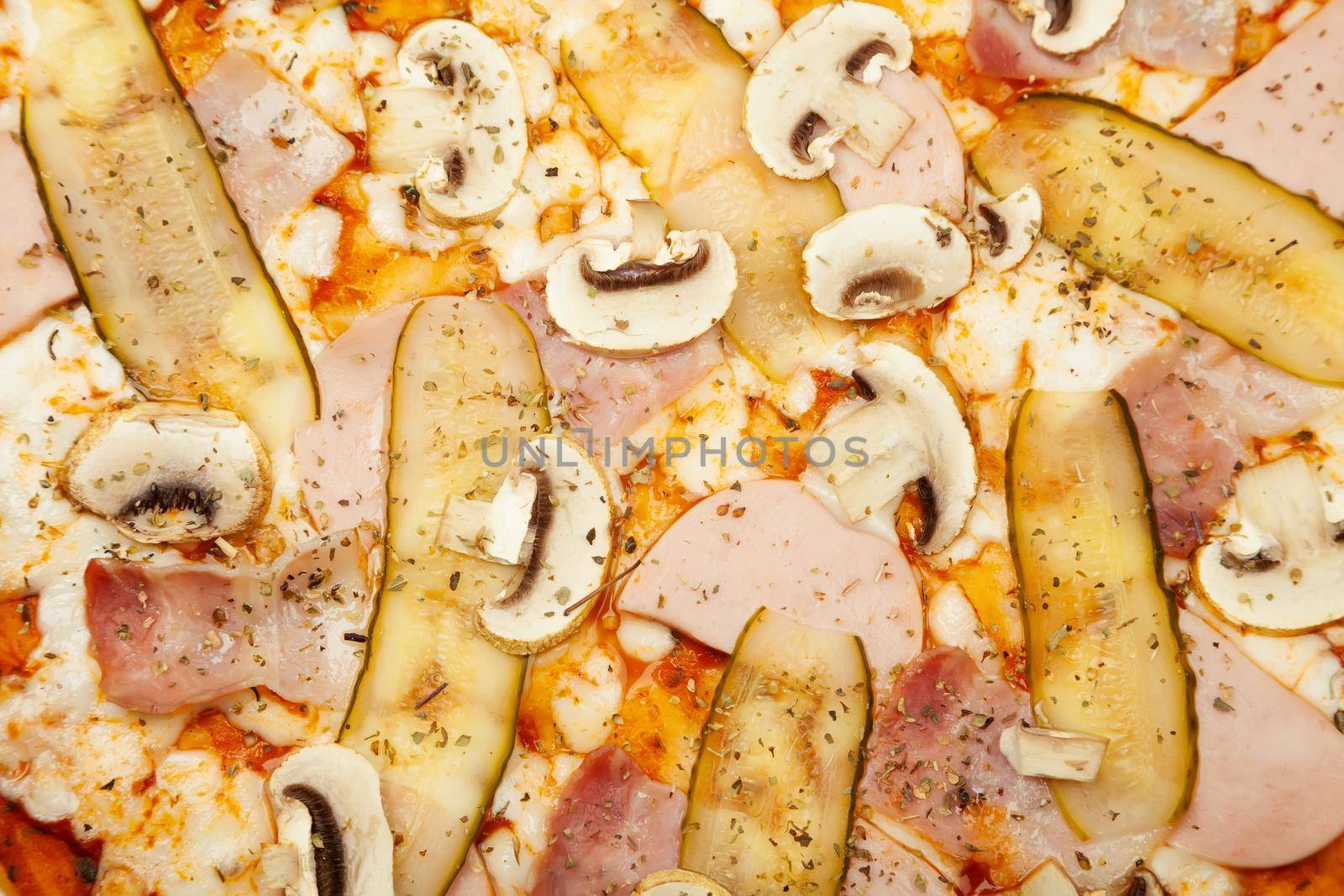 The texture of a delicious meat pizza served on a wooden plate, the ingredients are the signature sauce, mozzarella cheese, ham, bacon, pickled cucumber, champignons on white. Pizzeria promotion poster.