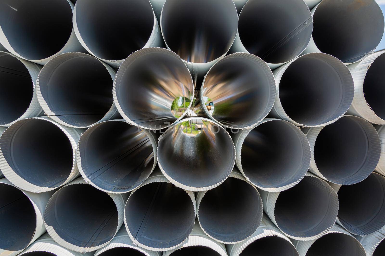 Downpipe warehouse. Steel pipes, parts for the construction of a roof drainage system in a warehouse. Stack of stainless steel pipes