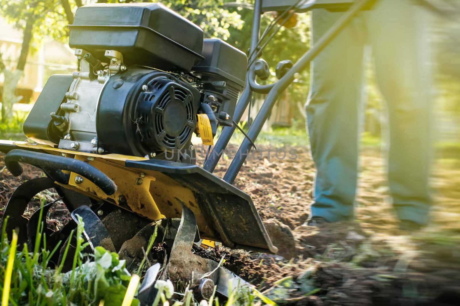 A close up view on motor cultivator during plow process spring season garden works concept