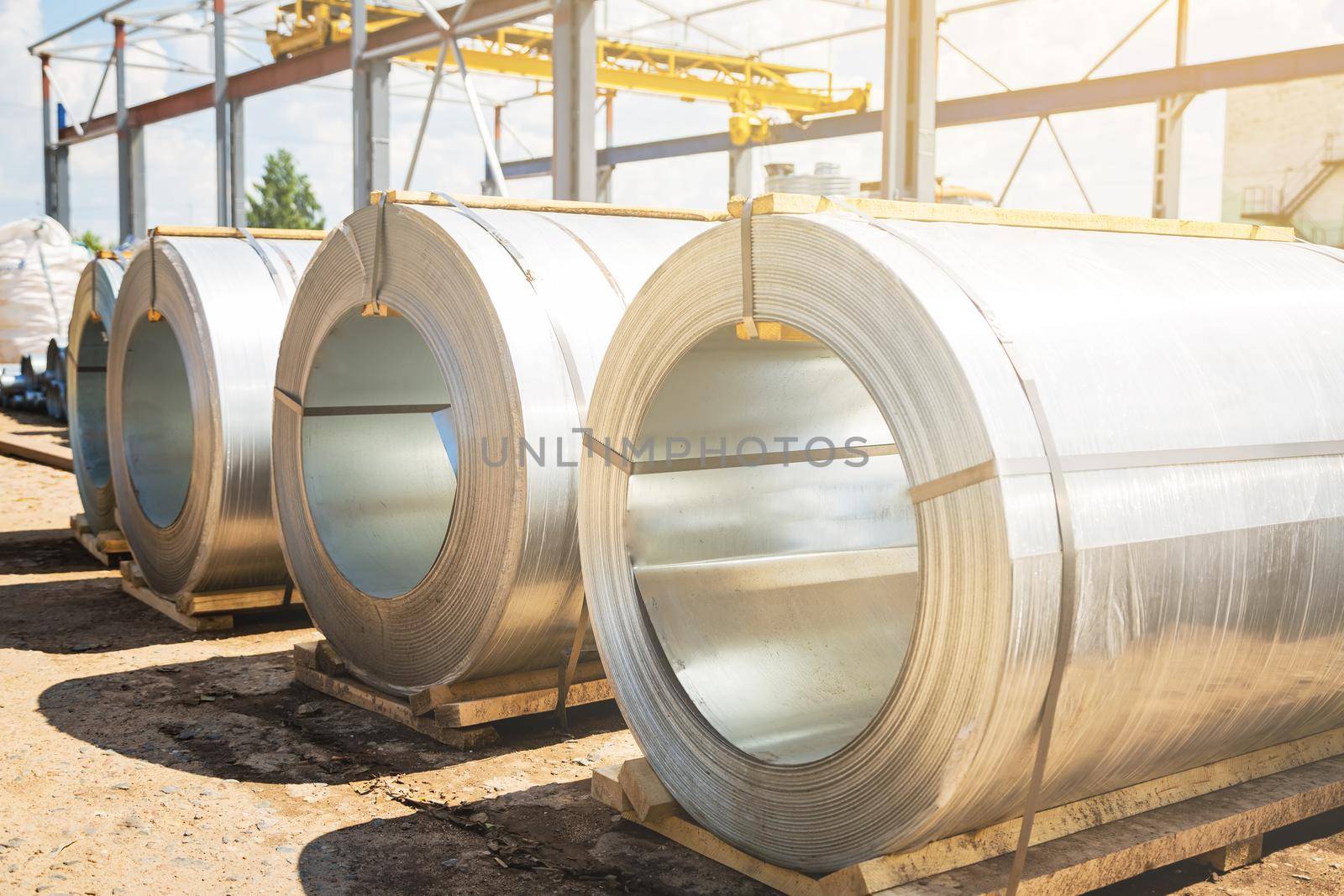 Stainless steel rolls. Rolls of steel sheet in the warehouse. A roll of galvanized steel sheet for the production of metal pipes and tubes in a factory