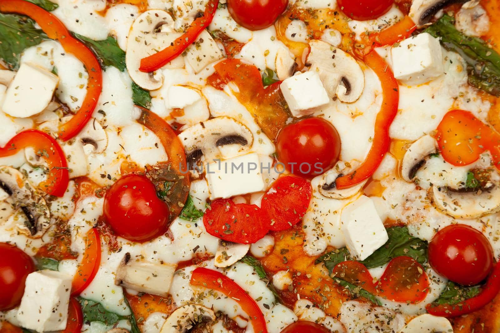 Delicious Vegetarian pizza served on a wooden plate, the ingredients are signature sauce, basil, mozzarella cheese, champignons, bell peppers, cherry tomatoes, feta cheese. Pizzeria promotion poster.