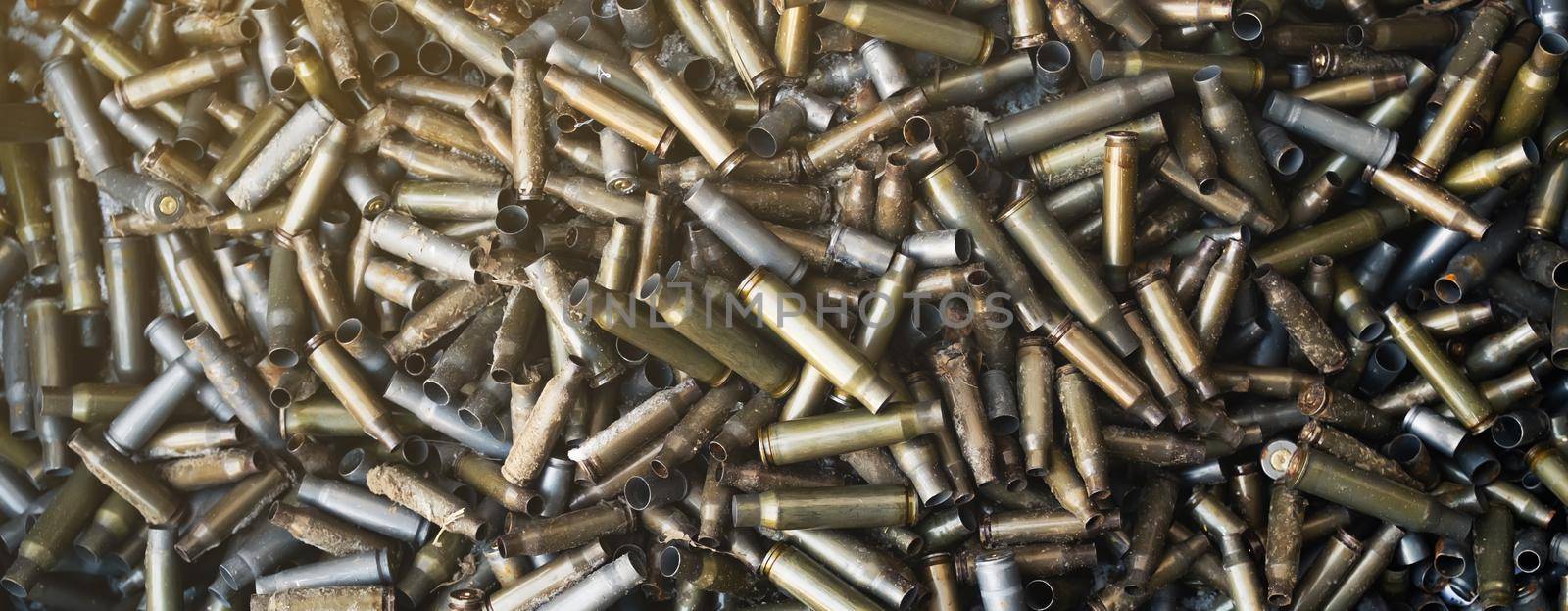 Empty carbine or rifle cartridges. A large number of cases. Background of brass ammunition cartridges to illustrate armed conflict, war or shooting