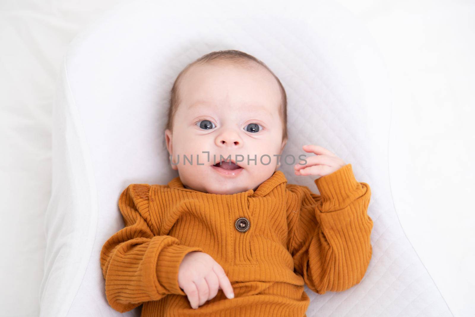 The baby is lying in a cocoon of copy space . The baby is 0-3 months old. A contented infant. An article about choosing a cocoon for newborns. An article about the benefits of cocoon. An article about colic . by alenka2194