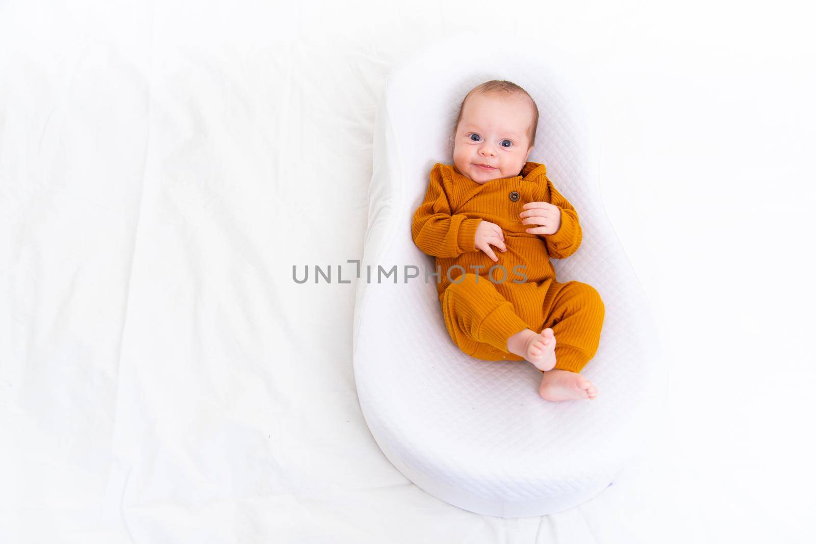 The baby is lying in a cocoon of copy space . The baby is 0-3 months old. A contented infant. An article about choosing a cocoon for newborns. An article about the benefits of cocoon. An article about colic . by alenka2194