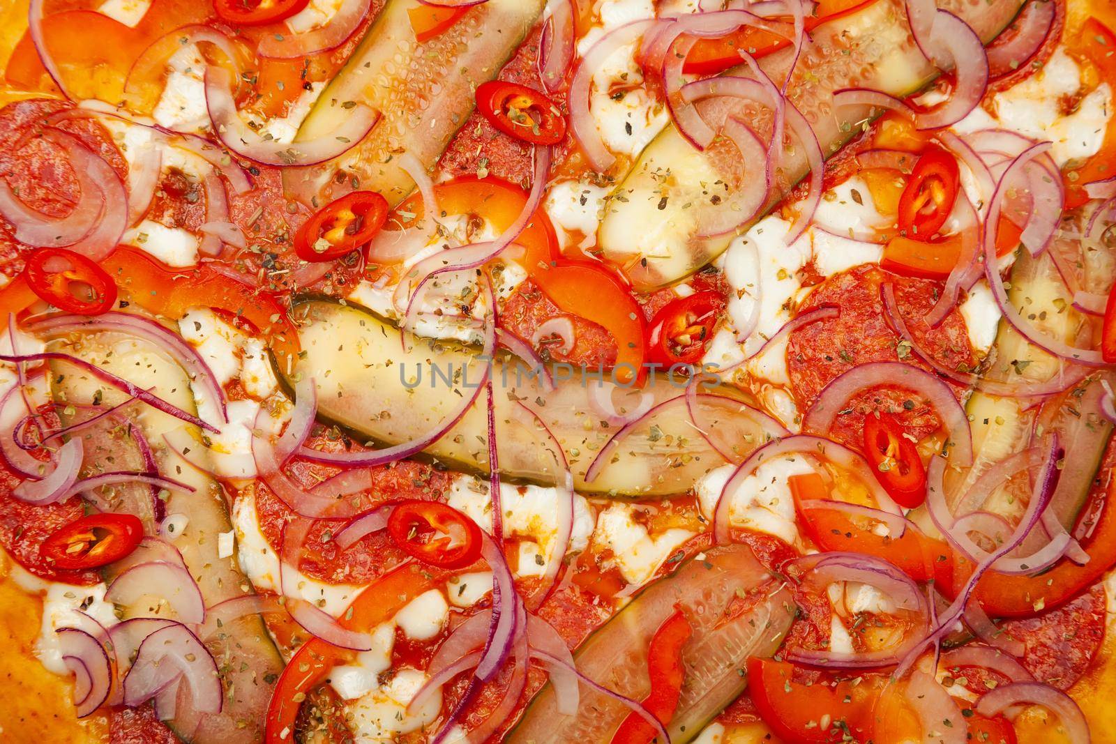 Texture of a delicious pizza Spicy pepper served on a wooden plate, ingredients Signature sauce, mozzarella cheese, pepperoni, pickled cucumber, bell pepper, red onion, chili pepper.