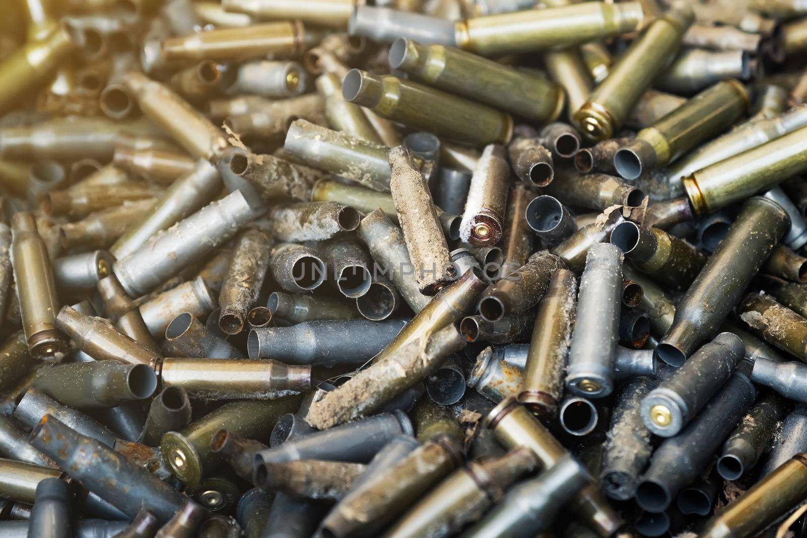 Empty carbine or rifle cartridges. A large number of cases. Background of brass ammunition cartridges to illustrate armed conflict, war or shooting