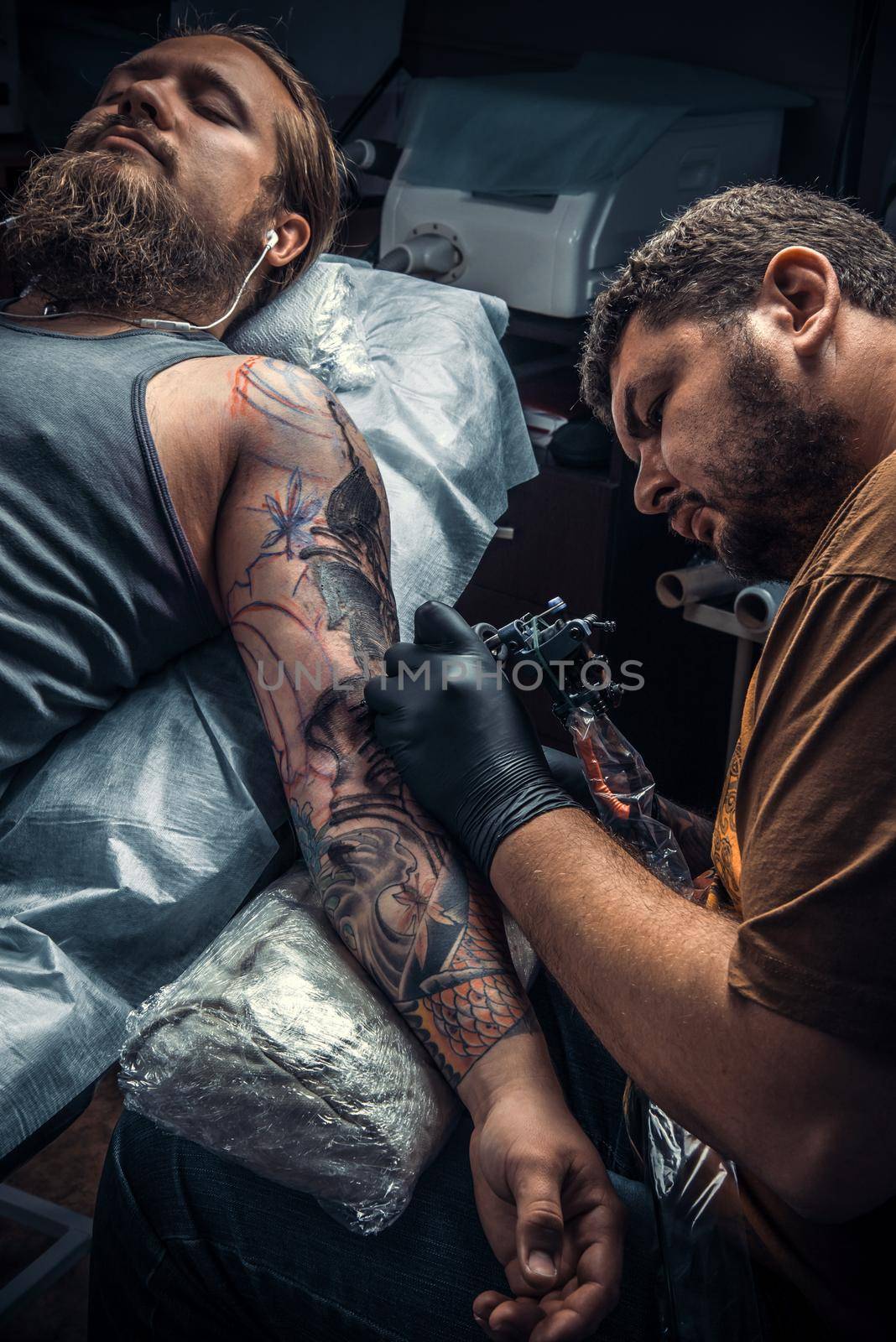 Professional tattooer create tattoo in tattoo studio./Professional tattooist makes tattoo in tattoo parlor.