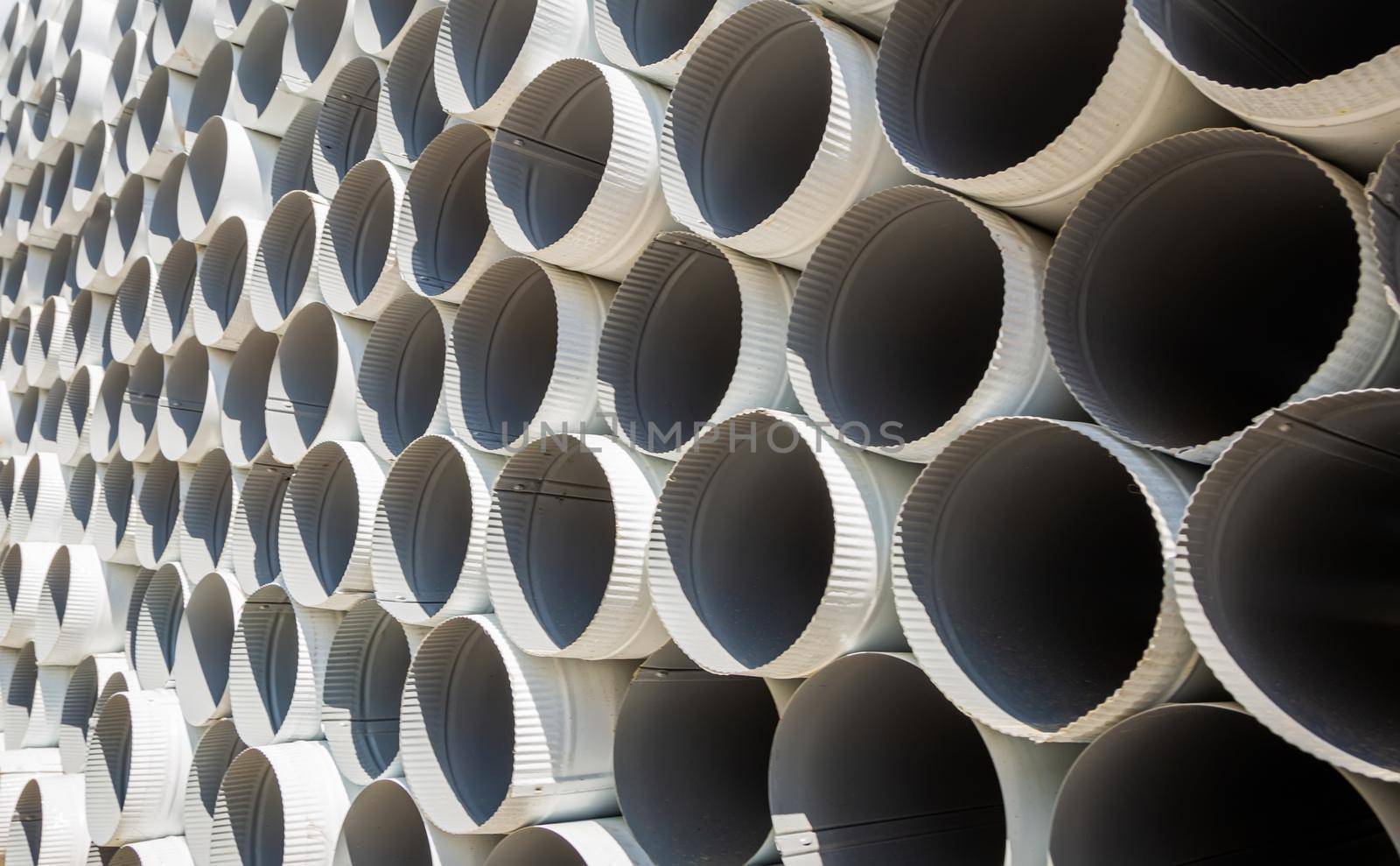 Downpipe warehouse. Steel pipes, parts for the construction of a roof drainage system in a warehouse. Stack of stainless steel pipes
