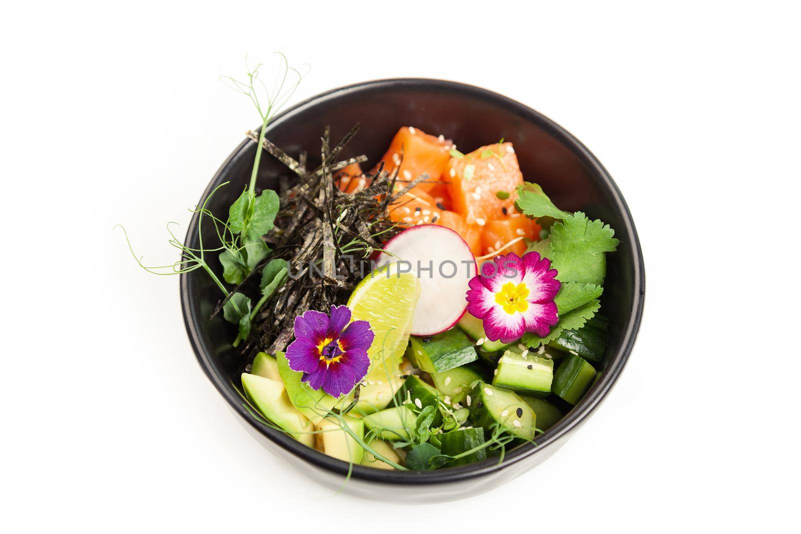 Poke with salmon in a bowl. Ingredients fresh salmon, avocado, cucumber, rice, Tamarind sauce, mango sauce, nori, lime, sesame seeds, cilantro. Seafood concept. Asian salmon poke salad on white plate.