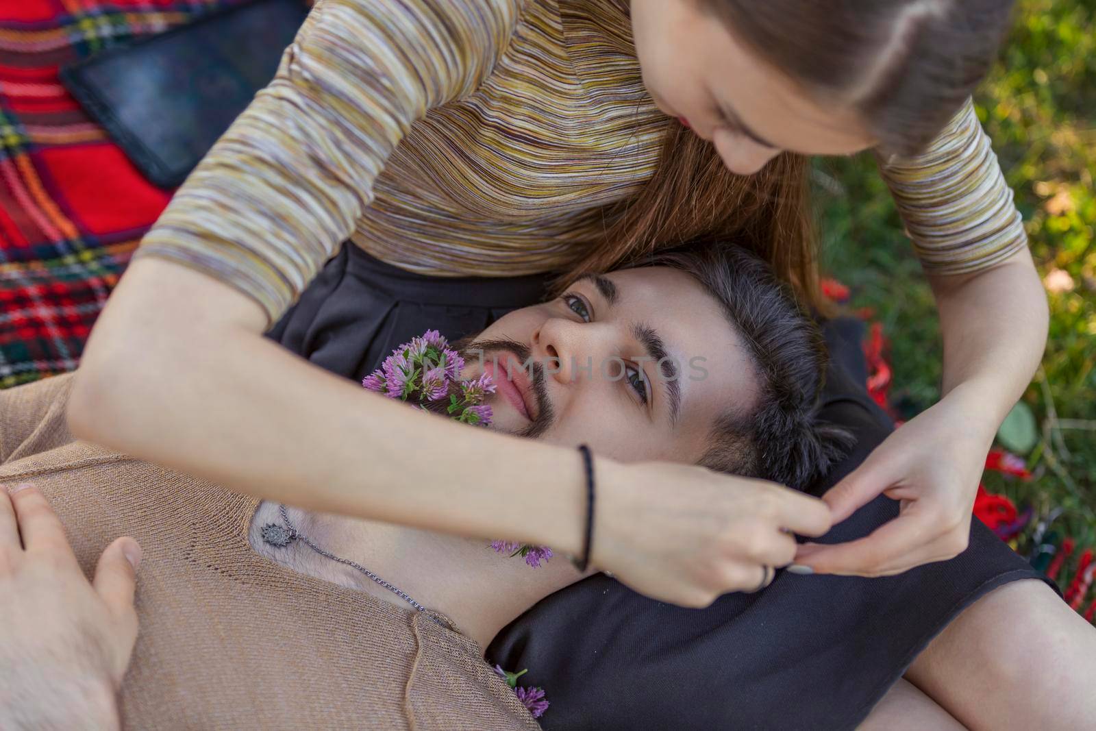 woman with a man in whose beard flowers in nature