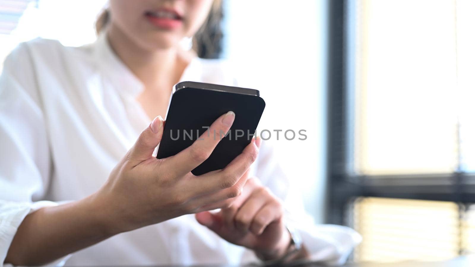 Cropped shot young asian woman and using smart phone for communicating in social network.